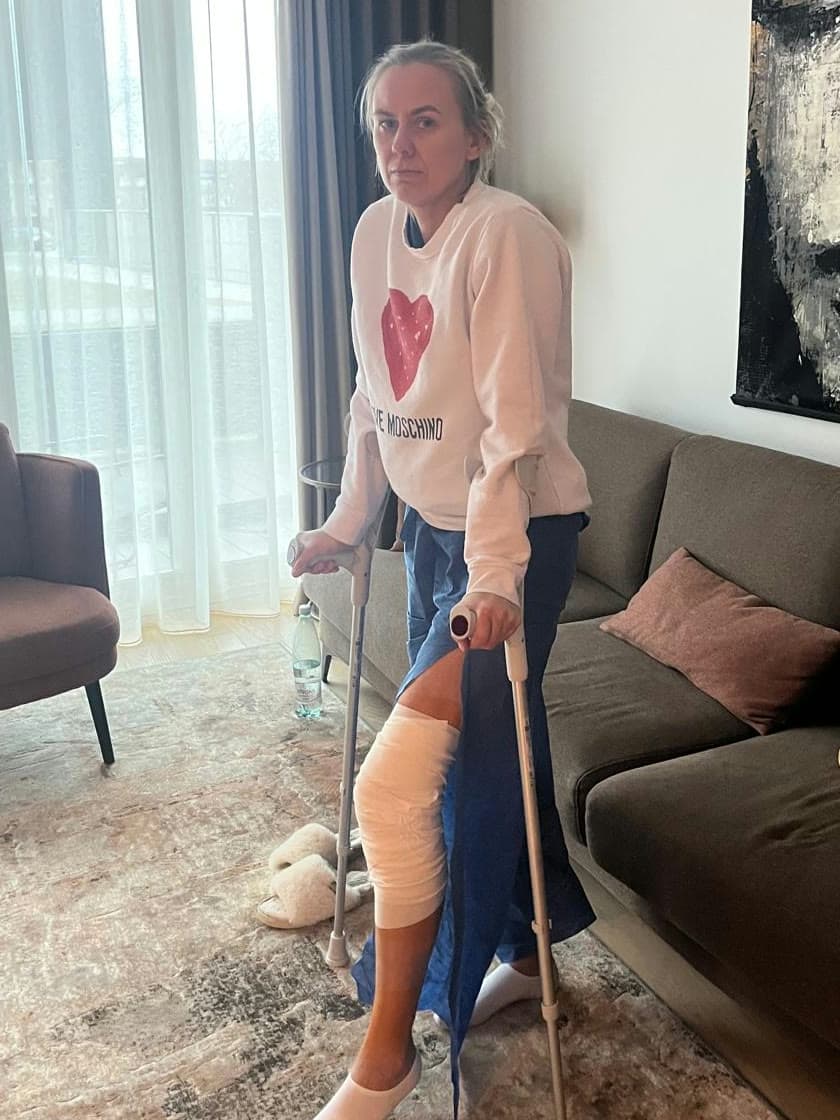 Berit standing on crutches with her knee strapped, after ACL surgery